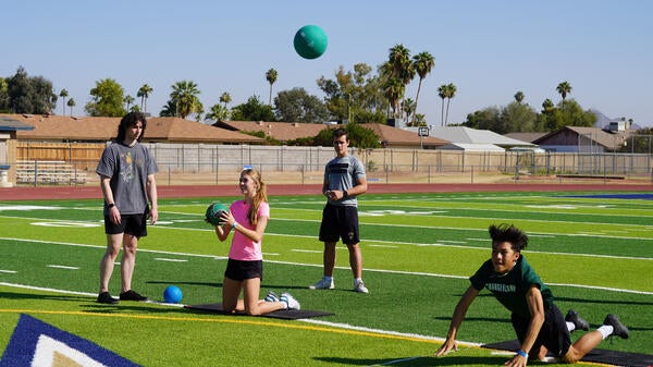 High school students playing sports on a field.