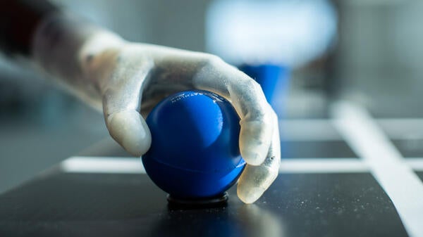 The SoftHand Pro prosthetic hand holding a ball. 