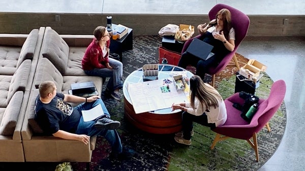 four students at the Devils Invent: Sustainable Health Solutions working around a table