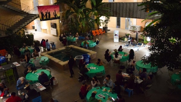 Aerial shot of Local to Global Justice event showing people sitting at tables inside an event hall.