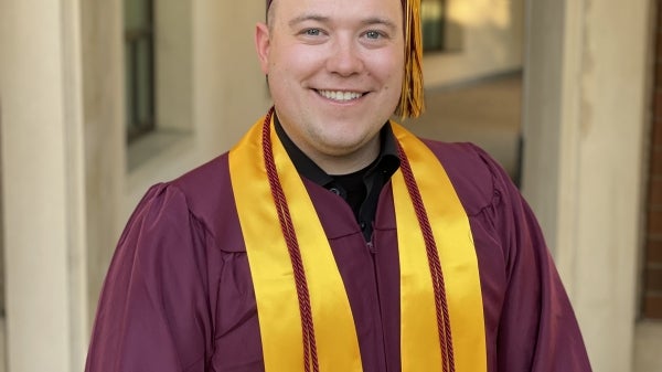 Dustin Vang stands with his ASU cap and gown on