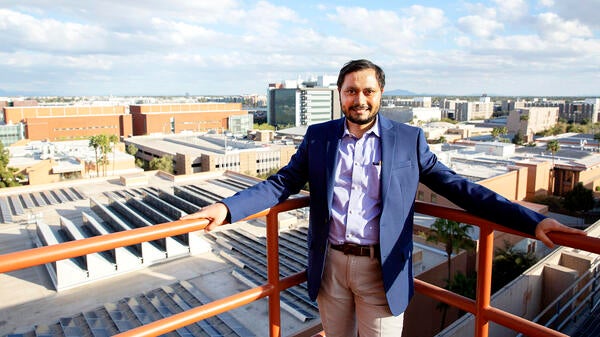 ASU Assistant Professor Anamitra Pal on a rooftop overlooking solar panels.