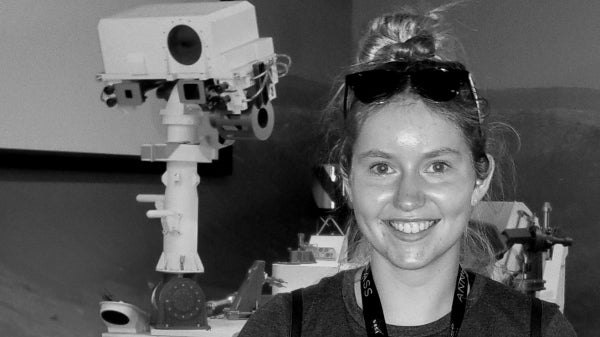 ASU graduate Emma Softich stands in front of a Mars rover.