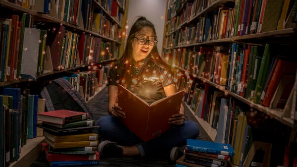 Girl in a library amazed by books