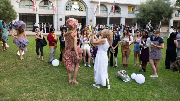 People mingling and examining fashion designs at outdoor event