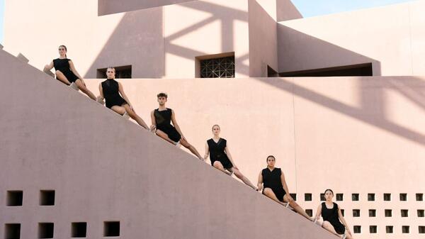 Six dancers pose on the diagonal steps of the ASU Art Museum, the lines of their leg matching the line of the architecture