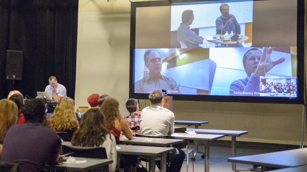 students watching live feed projection of person speaking