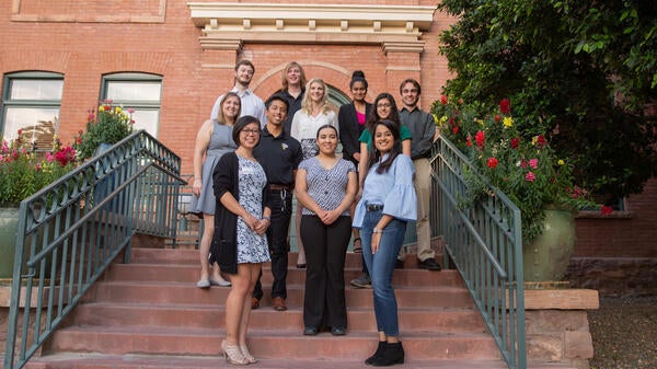 A group of students poses on the steps to the University Club building.