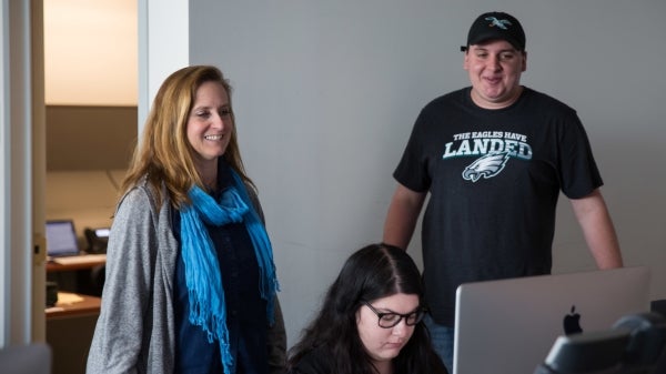 three people looking at a computer