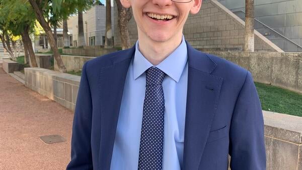 Nathaniel Ross wearing a dark blue suit with a light blue shirt and a dark blue tie