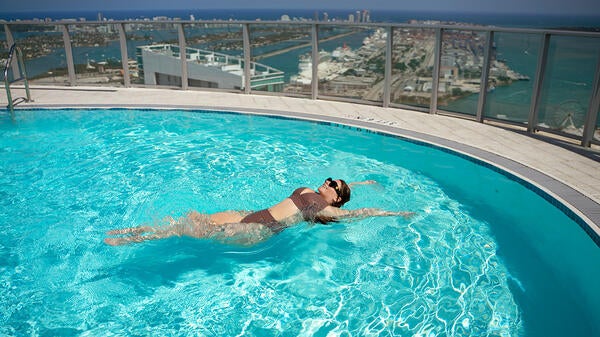 ASU alumna Demi George floats on her back in a rooftop swimming pool