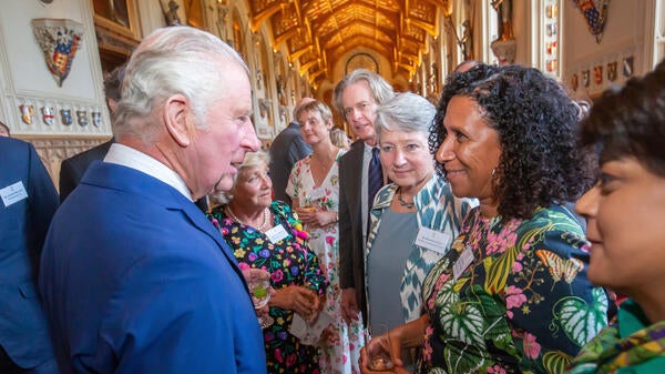 Ayanna Thompson and King Charles III greet each other in a group of people.