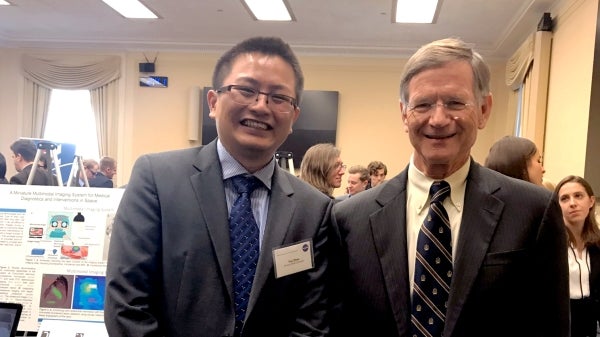 Yuji Zhao (left) poses with U.S. Representative Lamar Smith, chairman of the Committee on Science, Space, and Technology.