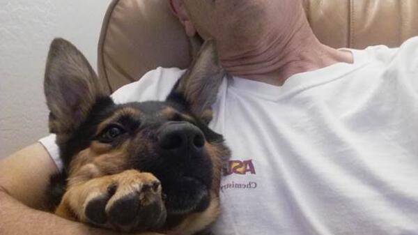 ASU Senior Lecturer Gary Cabirac seated in a recliner with a dog.