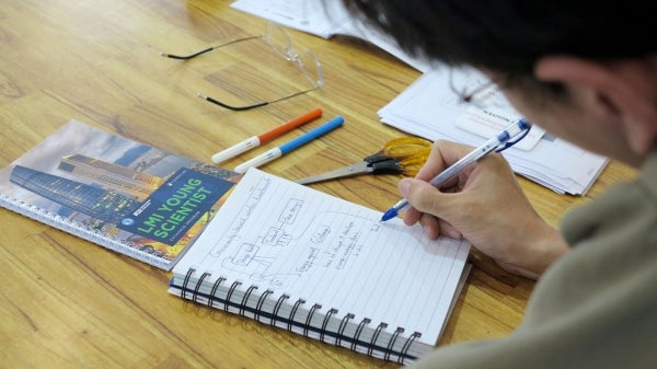 A Lower Mekong Initiative Young Scientist Program participant writes in a notebook. 