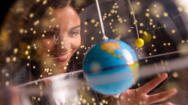 Woman looks through a clear globe