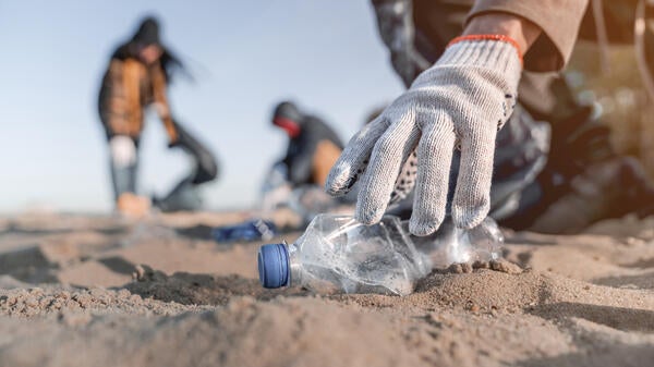 Hand picking up beach trash