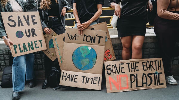 Protesters hold signs about the environment