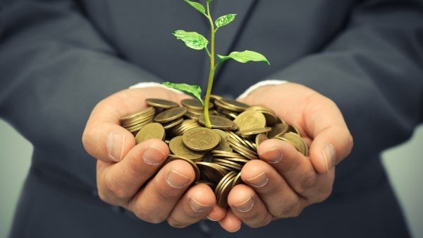 Man holding change and small plant