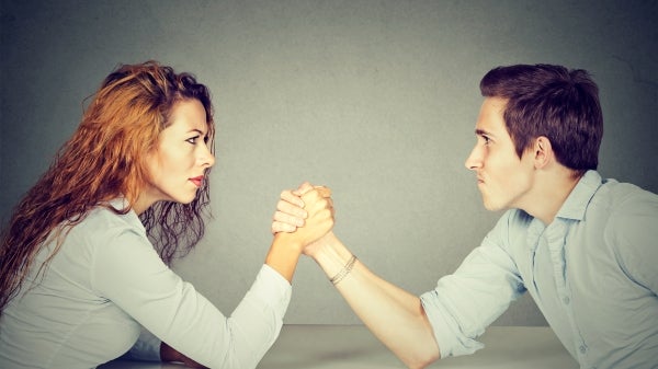 Woman and man arm wrestling