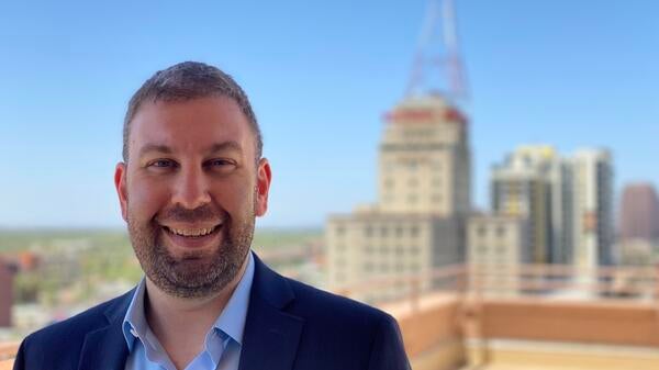 A photo of Jake Agron standing in front of the Westward Ho building in Downtown Phoenix.