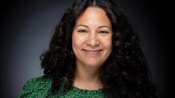 Graduating ASU student Katherine Santana Brickey smiles at the camera while wearing a green blouse.