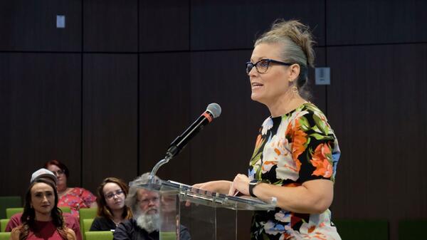 Katie Hobbs stands at a podium in front of an audience.