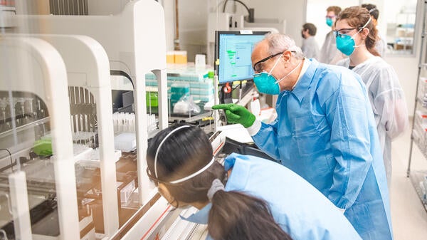 LaBaer and researchers look at machine used in COVID-19 testing in his laboratory