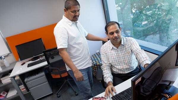 Two ASU researchers look at a computer.