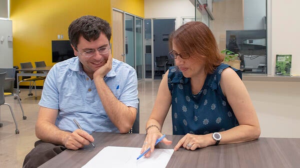 man and woman sitting at a table looking at a paper