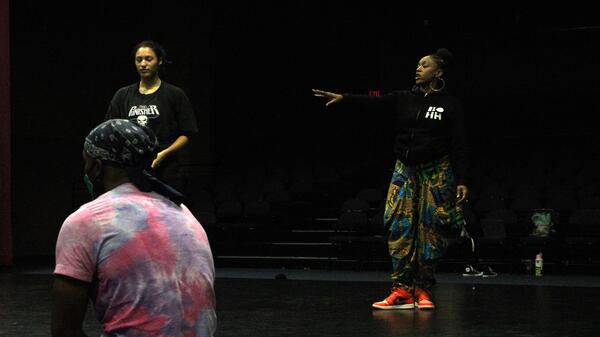 A group of people rehearsing onstage.