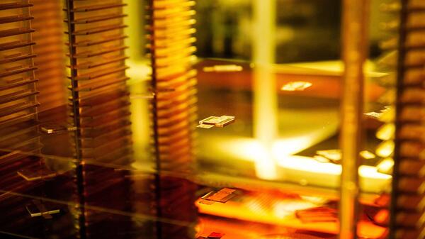 Semiconductor wafer on a rack lit by gold light