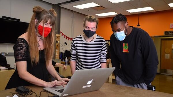 Photo of Lauren Copley and students working together during a workshop event