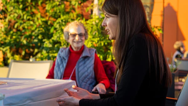 Older woman and college student smiling and talking.