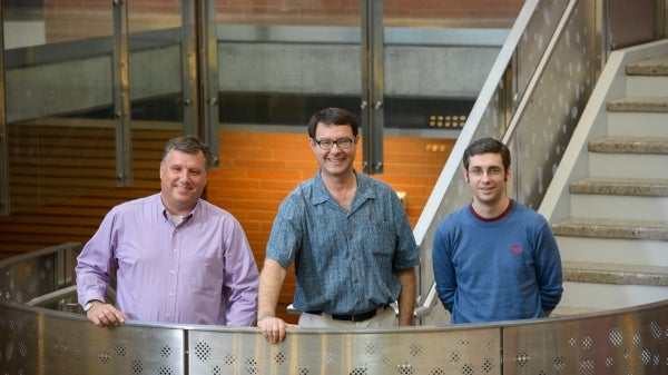 three men standing on stair case