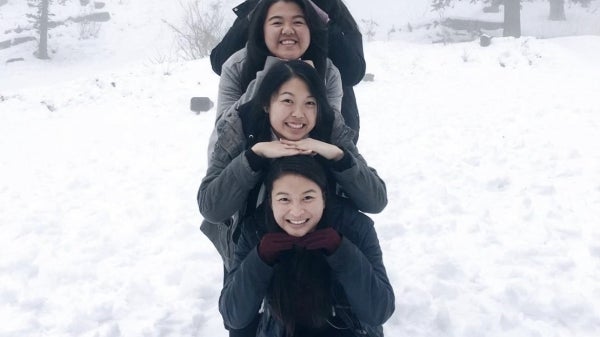 Nikki lines up with smiling friends on snowy landscape