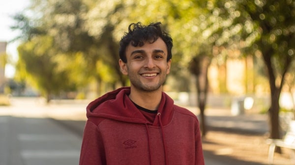 ASU grad student Belal Jamil smiling at the camera in an outdoor setting.