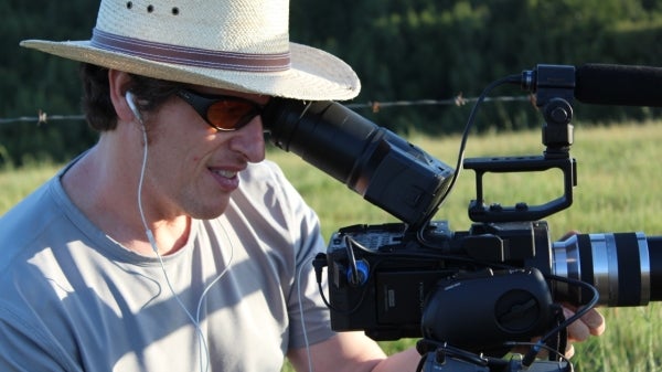 Peter Byck wearing a hat and sunglasses outside looking into video camera