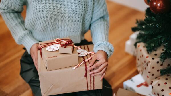 Person seated with wrapped gifts in their lap.