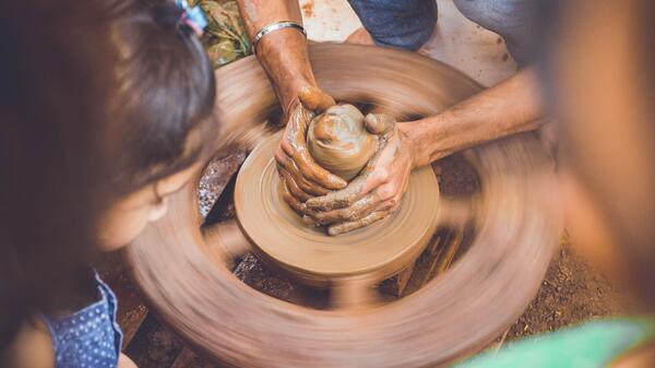 photo of hands at potter's wheel