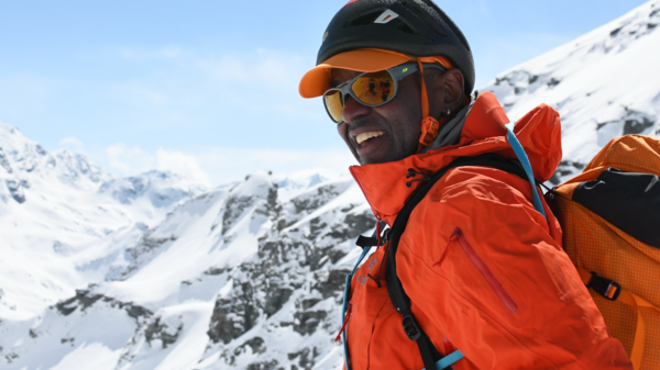 Portrait of ASU alumnus Robert Moody smiling in ski gear in front of a snowy mountain summit.