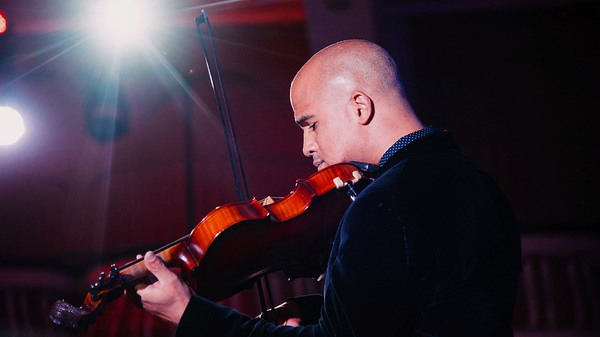 Daniel Bernard Roumain playing a violin.