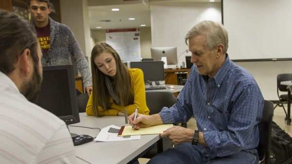 Stephen Krauses sits with students