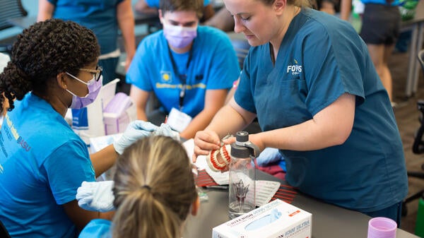 woman demonstrating dental technique to students