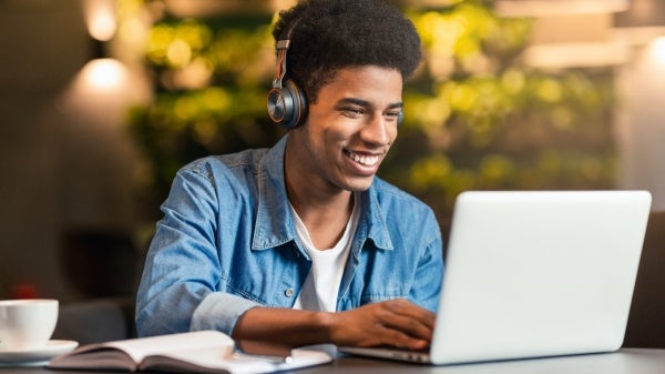 teen gamer playing video games on laptop