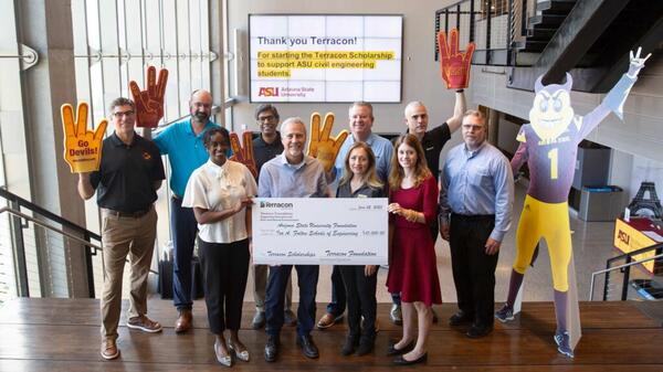 Members of the Terracon Foundation, the ASU Foundation and Professor Ram Pendyala standing at the top of a staircase holding a large check. A sign in the background reads "Thank you Terracon!" 