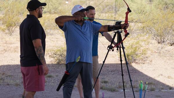 James Malone shoots an arrow as Rick Alvarado and Josh Parks watch