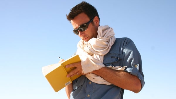 Christopher Stojanowski taking notes in the field