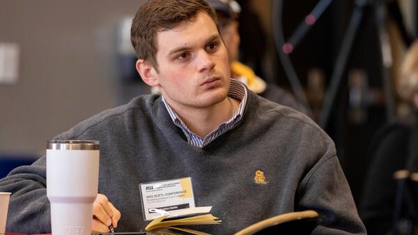 ASU student listening intently to a speaker at a School of Civic and Economic Thought and Leadership conference.