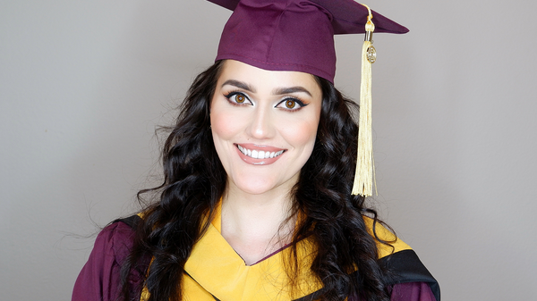 Portrait of ASU grad Tatyana Klyuchnyk wearing graduation gown, stole and cap and smiling at the camera.